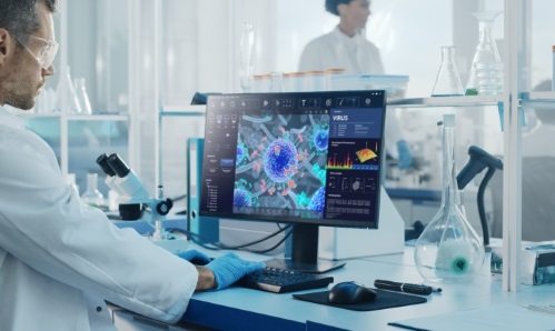 Scientist with safety goggles working at a computer